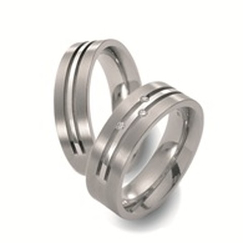 Moderne titanium trouwringen. De verdiepte lijnen benadrukken het strakke karakter van de ringen. In de dames trouwring pronken drie briljant geslepen diamanten.