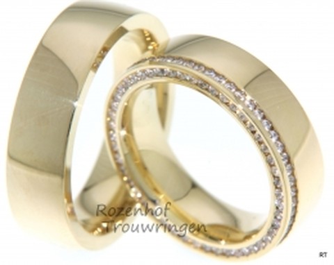 Prestigieuze geelgouden trouwringen. De ringen zijn 6 mm breed. In de dames trouwring is aan de buitenkant,zowel op de ring als aan de zijkant van de ring, een schitterende rand van briljant geslepen diamanten geplaatst.