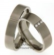 Modern vormgegeven titanium trouwringen van 5,5 mm. breed. De ringen hebben een matte finish.
In de heren ring is overdwars een verdiepte groef gezet.
In deze groef zijn in de dames trouwring 3 briljant geslepen diamanten van 0,06 ct. geplaatst. 2521-2522