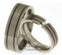 Titanium trouwringen, welke een breedte hebben van 5 mm. De ring is prachtig versierd met twee smalle, zwarte keramische ringen.
Als middelpunt is in de dames trouwring een zwevende, briljant geslepen diamant van 0,05 ct gezet. 2543-2544