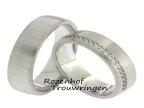 Moderne, 6 mm brede trouwringen van witgoud. De dames trouwring heeft een schitterende, sierlijke rand van 20 briljant geslepen diamanten van in totaal 0,20 ct. 3125-3126-8