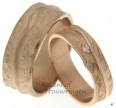 Gloedvolle roodgouden, ambachtelijke trouwringen. Verkrijgbaar in 6 of 8 mm breed. Ook verkrijgbaar in andere legeringen. Een glanzende lavarivier loopt golvend over de ring. In de dames trouwring zijn als fonkelende kraters twee briljant geslepen diamanten geplaatst.