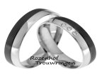 Mysterieuze trouwringen van glanzend witgoud met ruthenium. De ringen zijn 5 mm breed. In de dames trouwring schitteren 3 briljant geslepen diamanten van in totaal 0,045 ct.