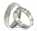 <p>Glanzende witgouden ringen met een breedte van 5 mm. In de ring is een verdiept pad aangebracht. In de dames trouwring zijn in dit verdiepte pad 12 briljant geslepen diamanten van in totaal 0,24 ct, als draaiende zonnetjes rondom de ring gezet.</p> 8607-8608