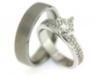 Bijzonder exclusieve trouwringen van witgoud met meer diamanten. De herenring is strak van vormgeving met een matte finish. De dames trouwring is schitterend bezet met een koninklijke diamant in het midden van de ring en aan weerszijden daarvan vele kleinere briljant geslepen diamanten.